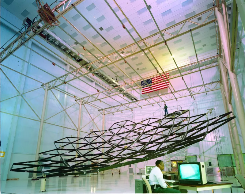Engineers testing a large lightweight solar concentrator frame in a hangar (NASA)