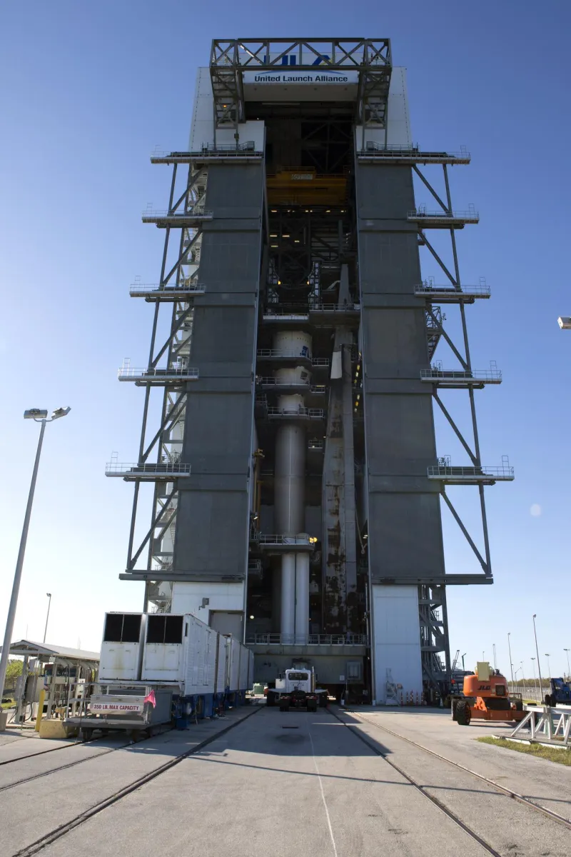 A satellite and upper stage lifted for mating to a rocket (NASA)