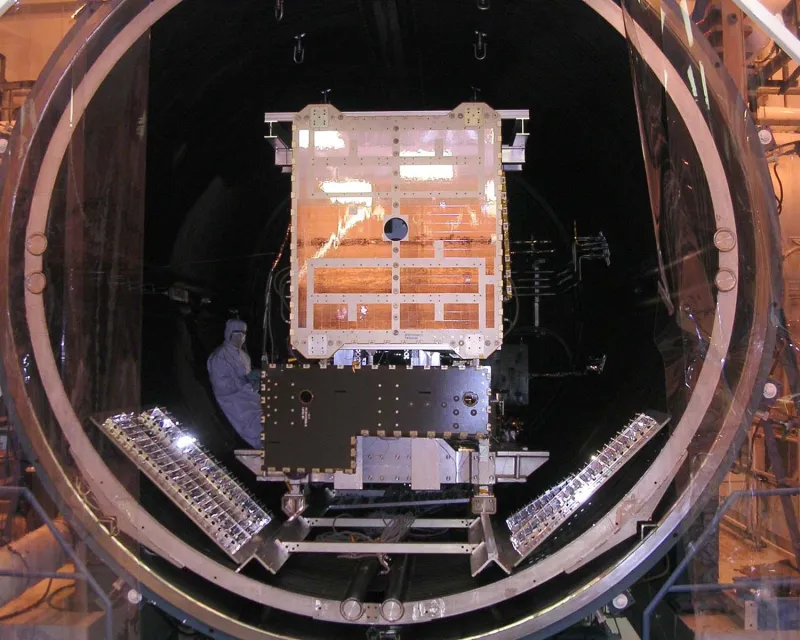 A spacecraft lowered into a thermal vacuum chamber (NASA)